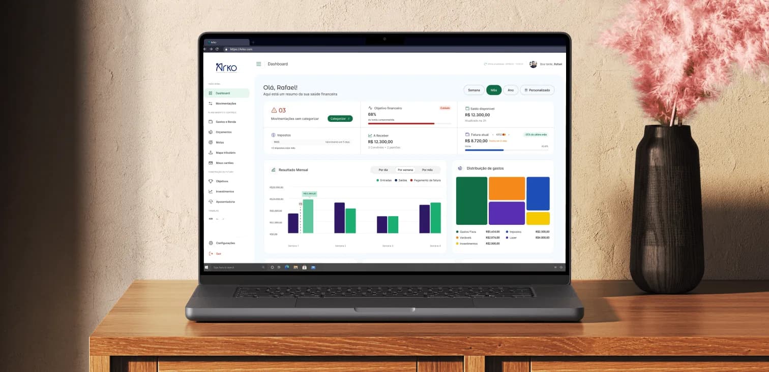 Arko — financial dashboard open on a MacBook over a wooden table